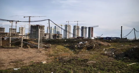 Field with construction debris, construction workers huts, large power cables 動画素材 244746856