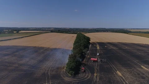 Field on fire with firefighters (drone) Stock Footage 92090943