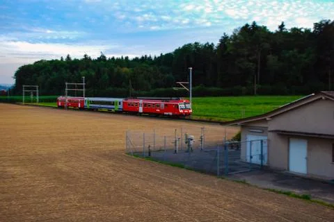Field, forest and passing train, Switzerland Фото