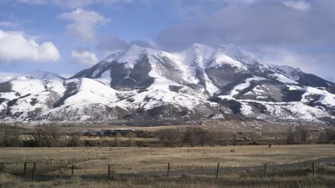 Field in front of snow covered mountains Stock Footage 113236332