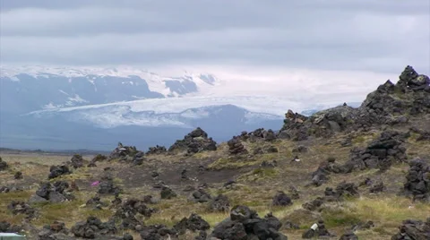 Field full of group of stone trolls or elves in front of glacier Stock Footage 37587683