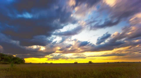 Field with  grass and  clouds. Shot in 4K 4096x2304  orange sunset Timelapse Stockbeeldmateriaal 52966115