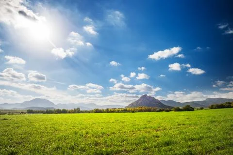 Field of green grass with mountains in the distance Stock Photos