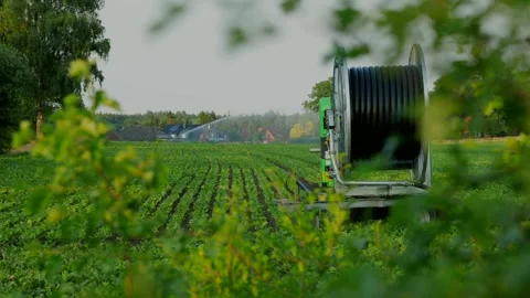 Field irrigation time lapse hose reel spraying unit field houses Oerzen Embsen Vídeos de archivo 244887829