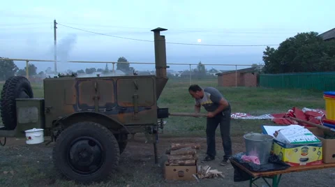 Field Kitchen. Evening Time. Man Taking Care of the Fire Stock Footage 65432343