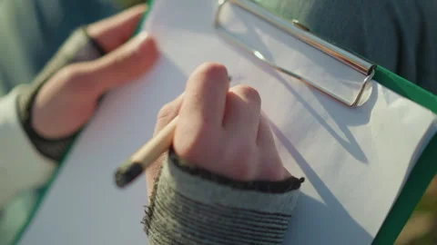 Field note taking, documenting data during field research activity, capturing Stock Footage 323223822