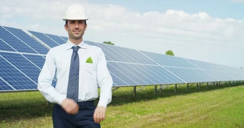 In a field of photovoltaic solar panels an engineer, check their ope Stock Footage
