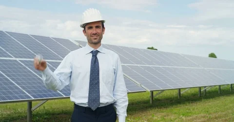 In a field of photovoltaic solar panels an engineer, check their ope Stock Footage