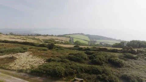 A field with a road running through it and a hill in the background Stock Footage 297951016