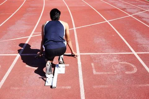 Field runner, back and man at start block at track for race, sports competition Stock Photos