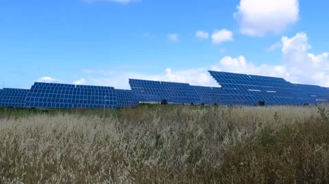 Field with solar panels and blue sky with clouds time-lapse Stock Footage 64804584