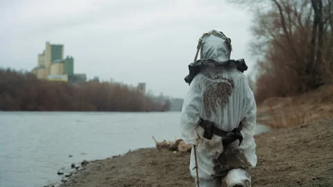 Field specialist dressed in gear studies contaminated shoreline silently. Tech Video stock 342746623