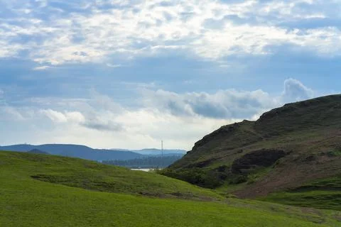 Field of spring grass and mountain Stock Photos