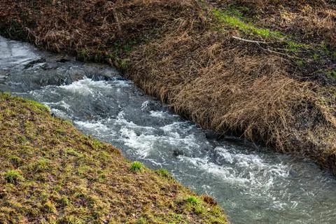 Field Stream Flowing Through Winter Landscape Foto stock