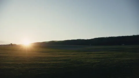 Field at sunset, camera pans with lens flare Stock Footage 276380590