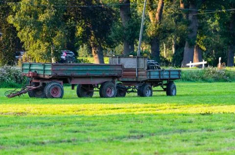 On a field there  are two trailers left by a farmer Stock Photos