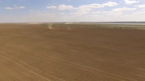 Field with tornadoes and a tractor at the background Bird eye view 動画素材 68863525