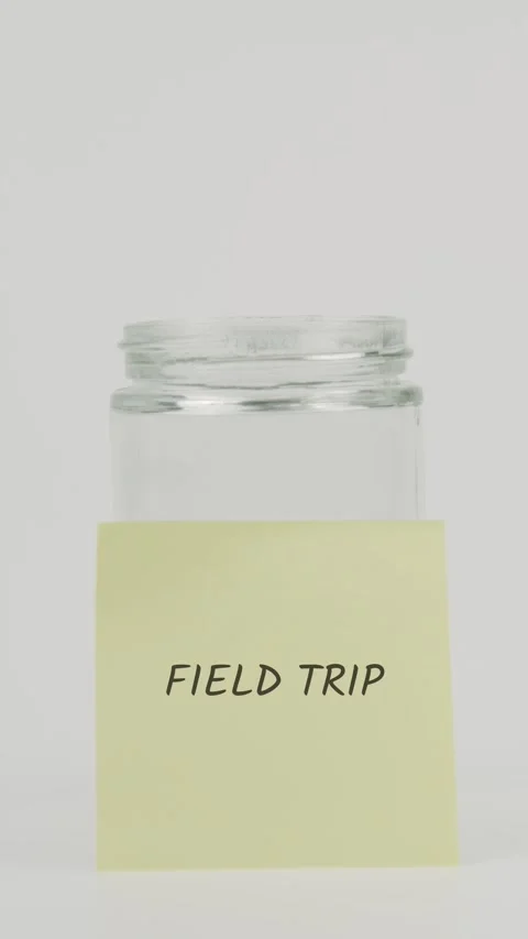Field trip text or word on yellow sticky note attached to glass jar with Stock Footage 311732420