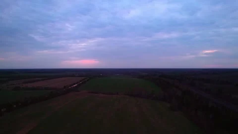 The field under the dark pink sky in the evening is taken from a drone. Stock Footage 196490100