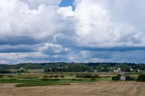 A field with a windmill in the distance Stock Photos