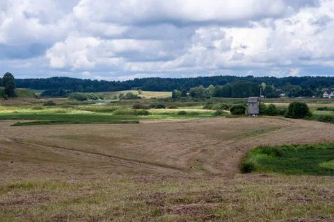 A field with a windmill in the middle Stock Photos