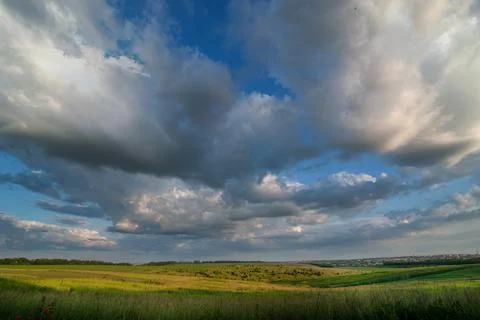 Fields and evening sky with clouds Stock Photos