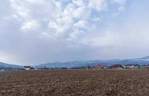 Fields and mountains under a cloudy sky at midday in a rural area Foto stock