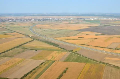 Fields, highway and suburb Stock Photos
