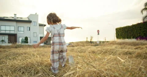 Fields of Joy: A Child's Delight in the Farm Life, Tossing Hay and Embracing Stock Footage 243518544