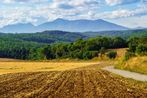Fields with mountains at the bottom of the sky with clouds at sunset on a summer Stock Photos