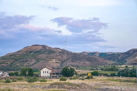 Fields in sunset factory and wind turbine in background Stock Photos