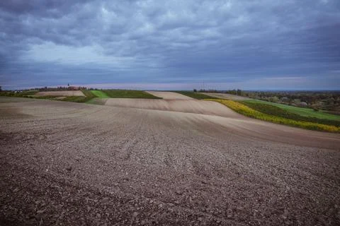 Fields of tilled earth under cloudy sky in autumn Stock Photos