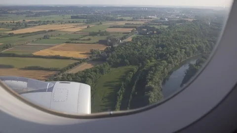 Fields, trees, river and European settlement seen through window of aircraft. Stock Footage 91786163