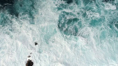 Fierce stormy waves, covered with foam, striking the rocky coast with great Stock Footage 99628043