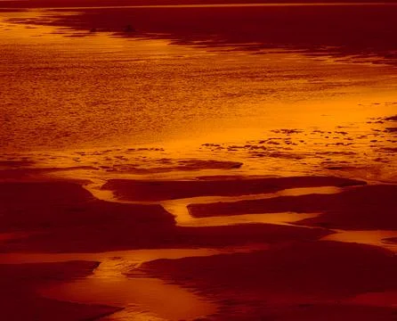 Fiery abstract texture of sand and water reflections in red and golden tones Stock Photos