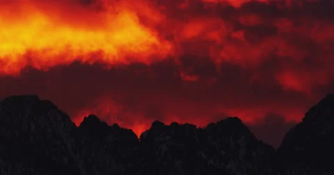 Fiery dawn clouds racing over peaks of Montana mountains Stock Footage 63080238