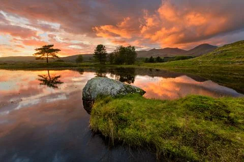 Fiery Dramatic Sunset Over Kelly Hall Tarn In The English Lake District. Stock Photos