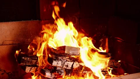 Fiery flames dance and crackle in the stove, casting a warm glow. Intense heat Stock Footage 266499287