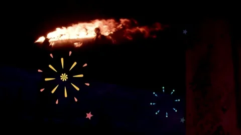 Fiery flames erupting against dark night sky with animated graphic starbursts Stock Footage 343804988