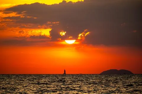 Fiery horizon, dramatic ocean sunset in vibrant hues over dark waters, natu.. Stock Photos