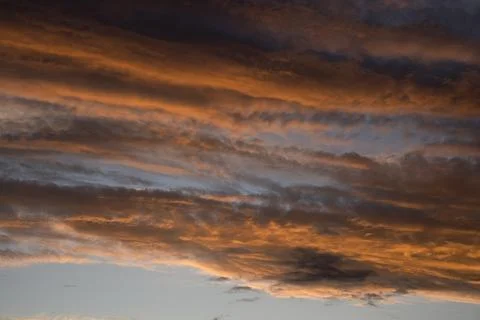 Fiery Orange Sunset Clouds in Dark Twilight Sky Stock Photos