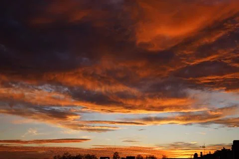 Fiery orange sunset sky with red clouds. Beautiful sky. Stock Photos