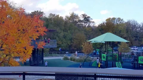 Fiery orange tree over modern suburban playground full of kids during pandemic Vídeo Stock 143684543