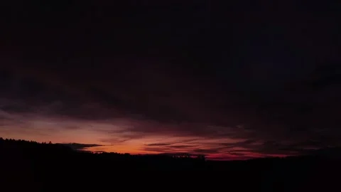 Fiery, peaceful sunset, side-downward movement before silhouette of trees, drone Stock-Footage 140220711
