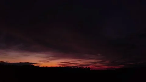 Fiery peaceful sunset, side-downward movement before silhouette of trees, drone Stock-Footage 140220725