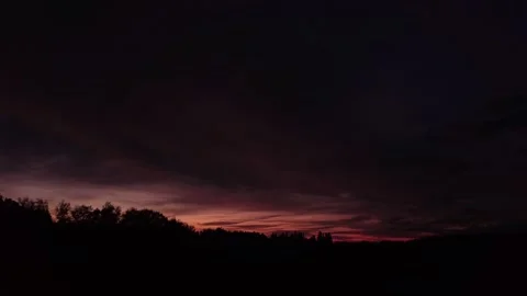 Fiery, peaceful sunset, side-upward movement before silhouette of trees, drone. 스톡 동영상 140220746