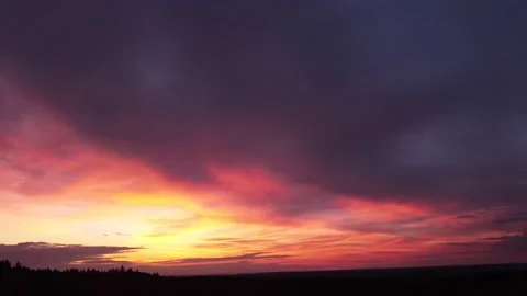 Fiery, peaceful sunset, sideward movement before trees, drone shot. Stock-Footage 140221479