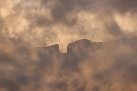 Fiery Peak in a Cloud Embrace Stock Photos