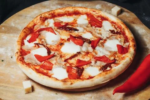 Fiery Pepper Pizza on Rustic Cutting Board 库存照片