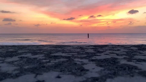 Fiery pink sunset with waves breaking over rocks Okinawa Japan Stock-Footage 125427132